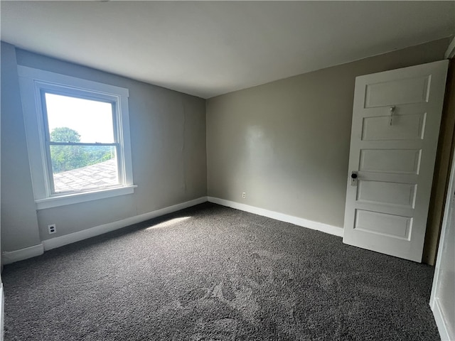 spare room with dark carpet