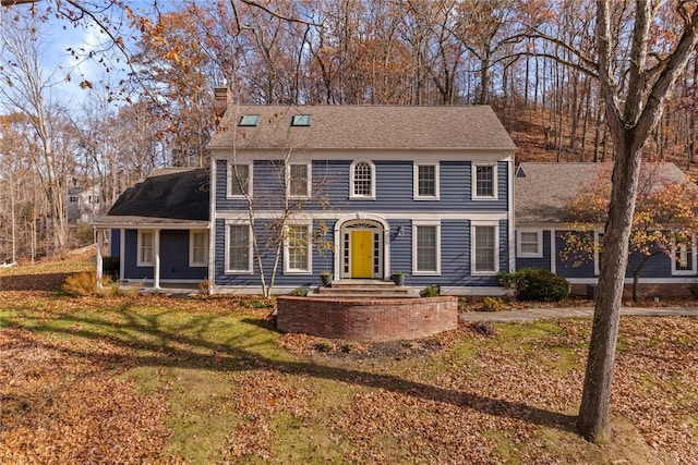 colonial-style house with a front lawn