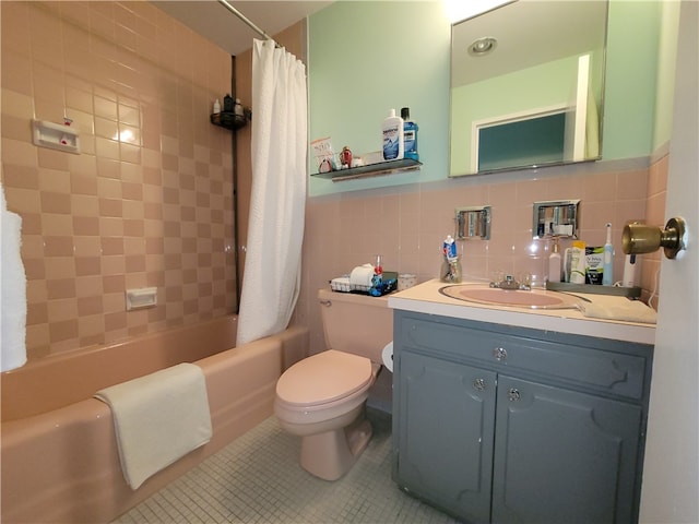 full bathroom with tile patterned floors, toilet, tile walls, and shower / tub combo with curtain