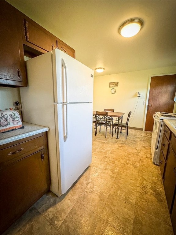 kitchen with dark brown cabinetry and white appliances