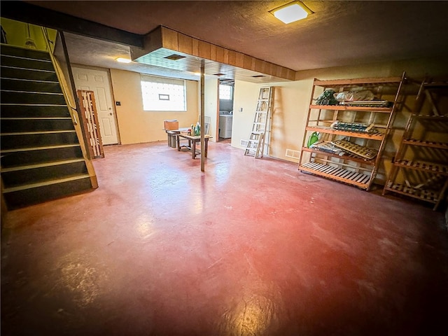 basement with washer / clothes dryer and a textured ceiling