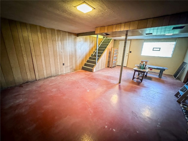 basement featuring wooden walls