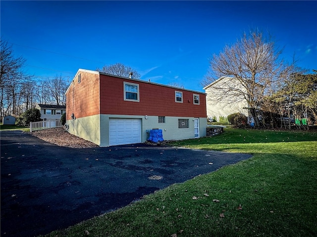 back of property with a yard and a garage