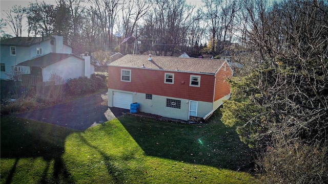 rear view of house with a lawn and a garage