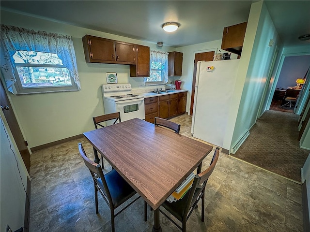 kitchen featuring light carpet, white appliances, and sink