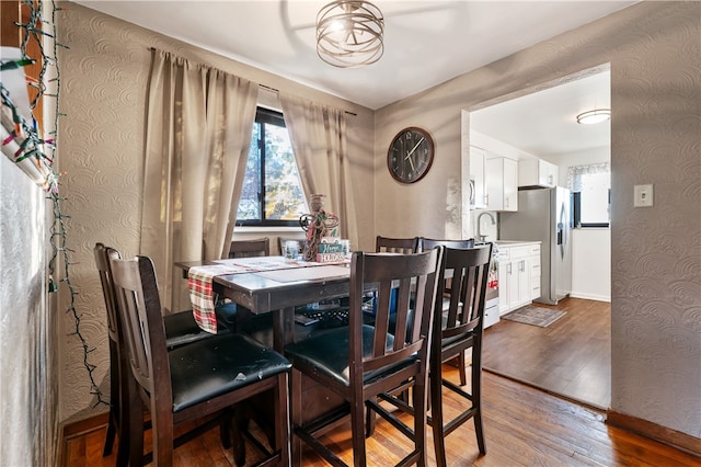 dining area with sink and wood-type flooring