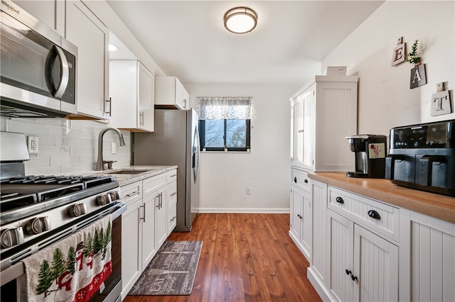 kitchen with white cabinetry, sink, stainless steel appliances, tasteful backsplash, and dark hardwood / wood-style flooring