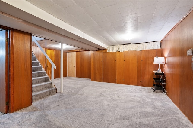 basement with carpet flooring and wooden walls