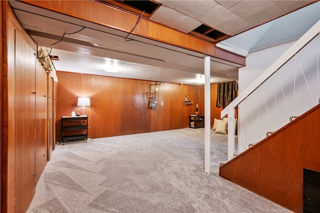 basement featuring wood walls and light colored carpet