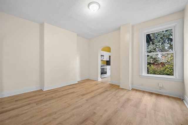 unfurnished room with light hardwood / wood-style floors and a textured ceiling