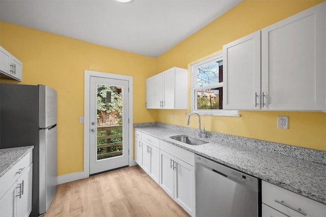 kitchen featuring appliances with stainless steel finishes, white cabinetry, a healthy amount of sunlight, and sink