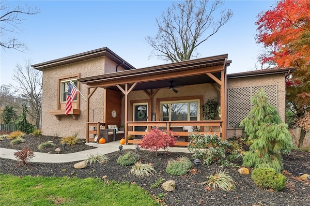 rear view of property featuring ceiling fan and covered porch