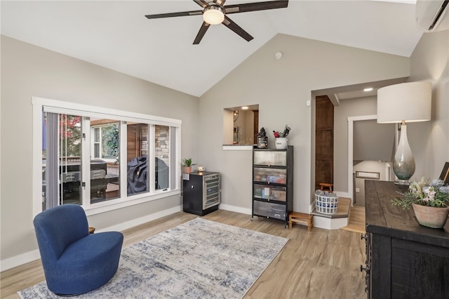 sitting room featuring a wall mounted air conditioner, ceiling fan, light hardwood / wood-style floors, and high vaulted ceiling