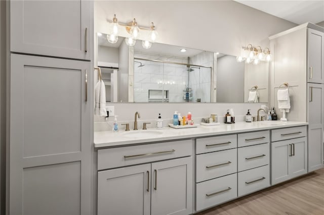 bathroom with vanity, an enclosed shower, and hardwood / wood-style flooring