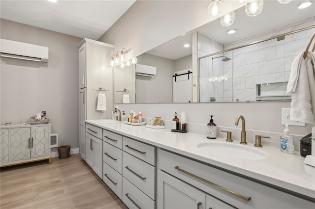 bathroom featuring hardwood / wood-style floors, vanity, an AC wall unit, and a shower with shower door