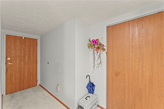 entryway with light carpet and a textured ceiling