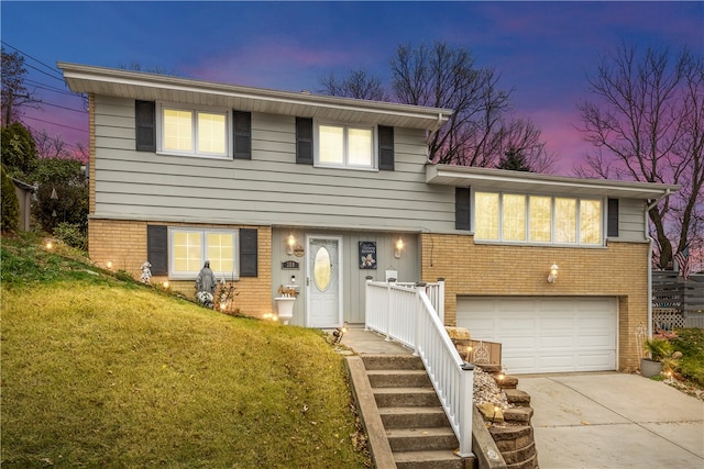 split level home with a yard and a garage