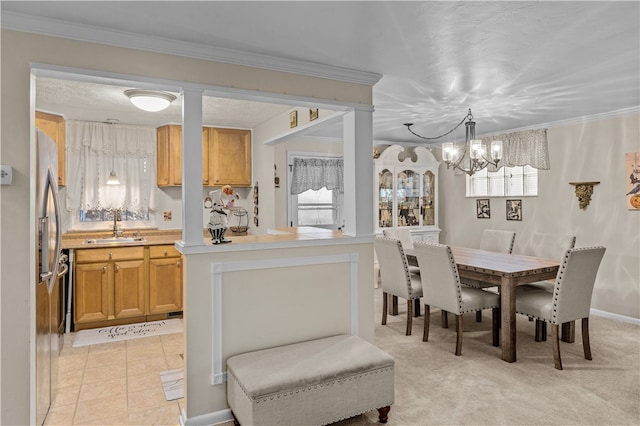 dining space featuring sink, light colored carpet, a chandelier, and ornamental molding