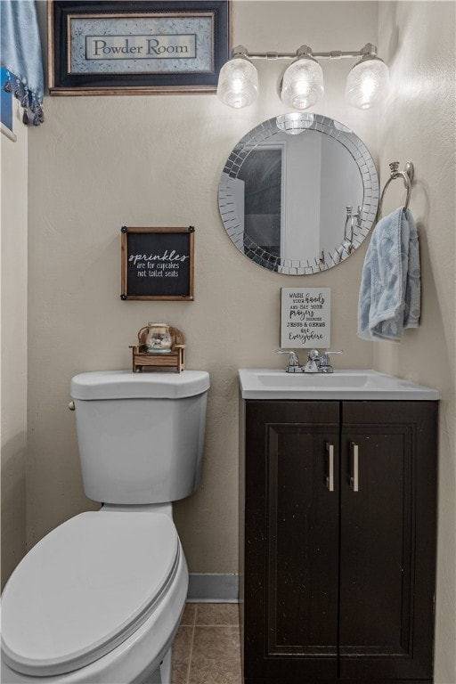 bathroom with tile patterned flooring, vanity, and toilet