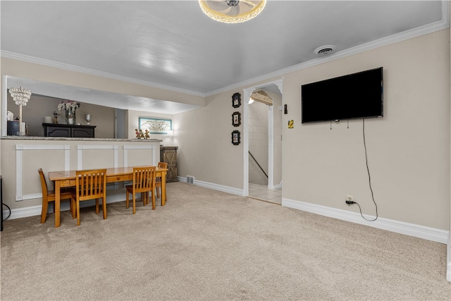 dining area featuring crown molding and light carpet