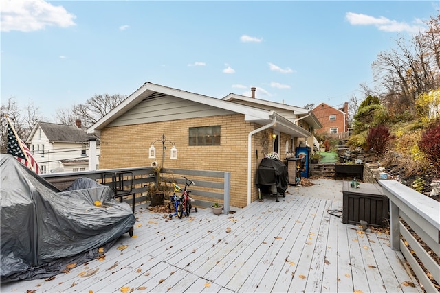 wooden deck featuring a grill