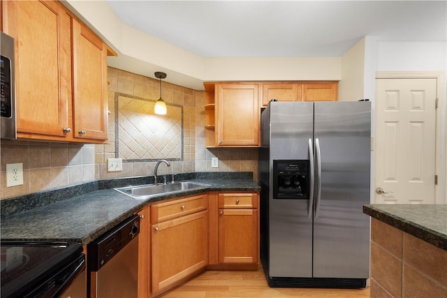 kitchen with sink, light hardwood / wood-style flooring, appliances with stainless steel finishes, tasteful backsplash, and decorative light fixtures