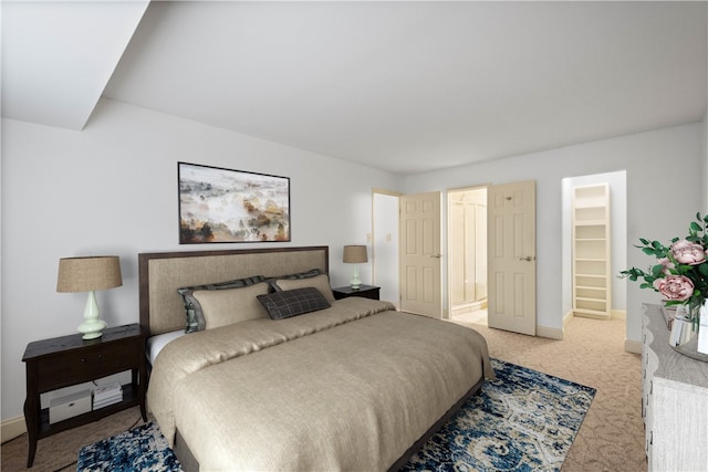 bedroom featuring a walk in closet, a closet, and carpet