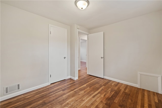 empty room with dark hardwood / wood-style flooring