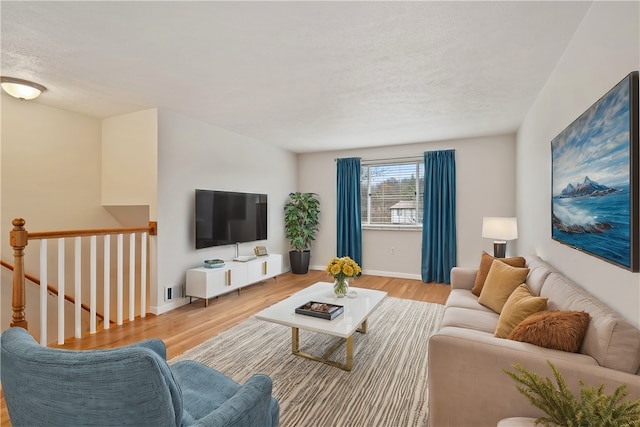 living room featuring light hardwood / wood-style floors and a textured ceiling