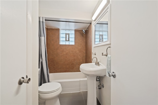 bathroom featuring tile patterned flooring, toilet, and shower / tub combo