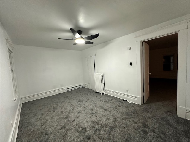 unfurnished bedroom with ceiling fan, radiator heating unit, and dark colored carpet