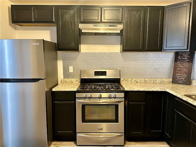 kitchen with dark brown cabinetry, appliances with stainless steel finishes, light stone counters, and decorative backsplash