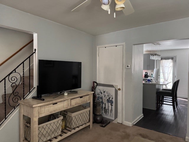 living room featuring ceiling fan and dark colored carpet