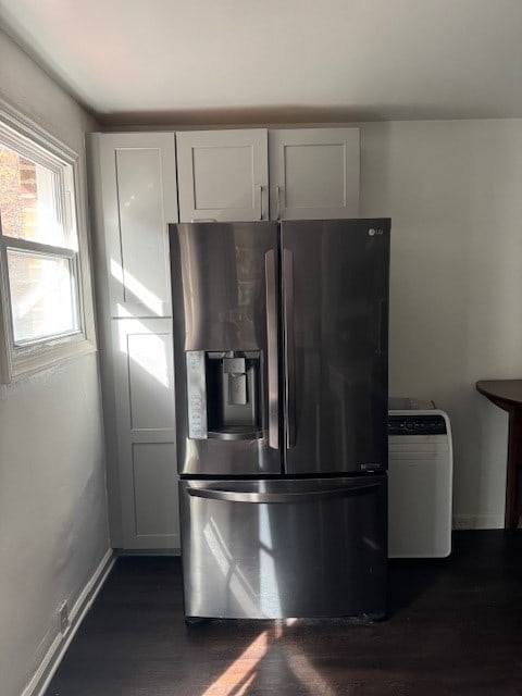 kitchen with white cabinets, stainless steel fridge, and dark wood-type flooring