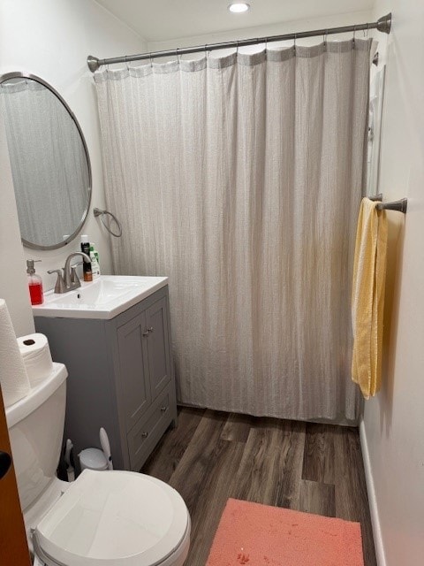 bathroom featuring a shower with shower curtain, vanity, hardwood / wood-style flooring, and toilet