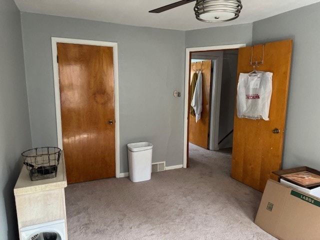 interior space featuring light carpet and ceiling fan