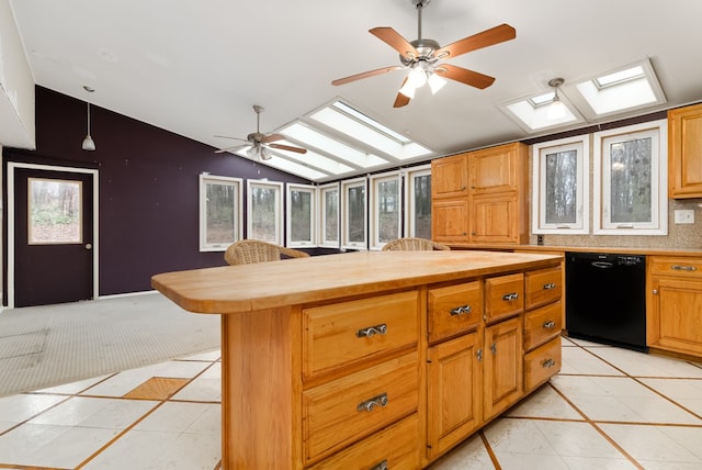 kitchen with dishwasher, a kitchen island, wooden counters, lofted ceiling with skylight, and light tile patterned floors