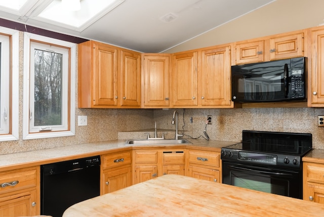 kitchen featuring wood counters, black appliances, sink, vaulted ceiling, and tasteful backsplash