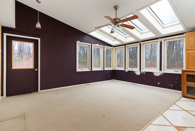 unfurnished sunroom featuring a wealth of natural light, vaulted ceiling with skylight, and ceiling fan