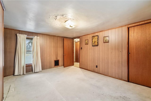 carpeted empty room with wooden walls