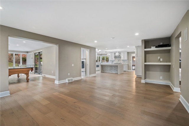 unfurnished living room with billiards and light hardwood / wood-style flooring