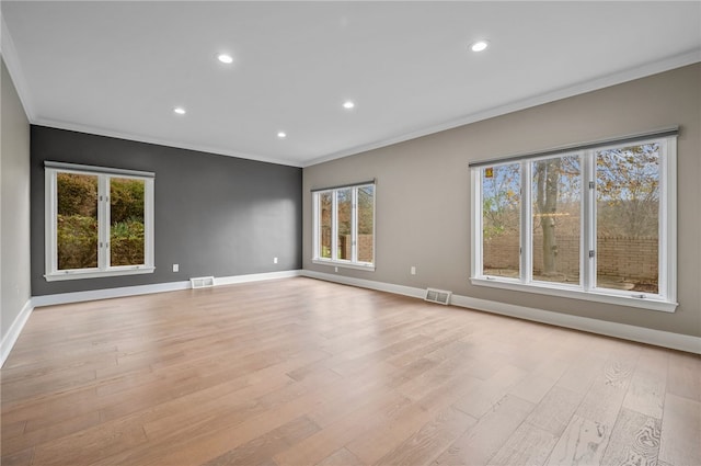 unfurnished room with plenty of natural light, light hardwood / wood-style floors, and ornamental molding