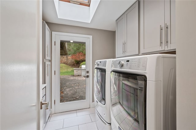 laundry room with cabinets, separate washer and dryer, light tile patterned floors, and a skylight