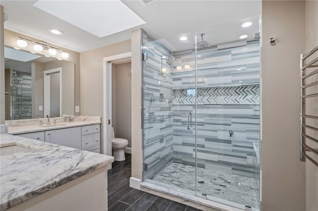 bathroom featuring an enclosed shower, vanity, and toilet