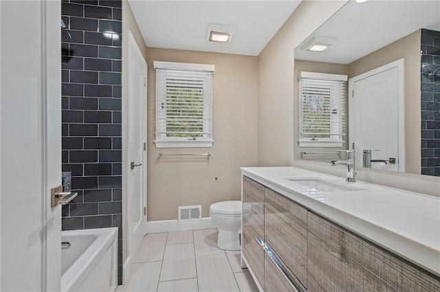 full bathroom featuring tile patterned flooring, vanity, toilet, and tiled shower / bath combo