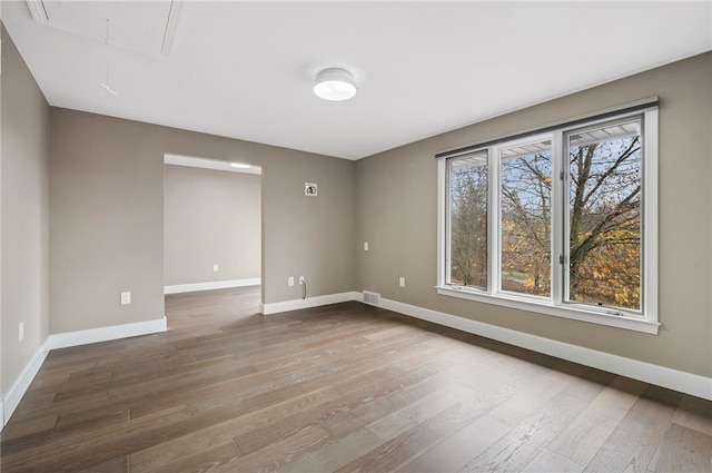 unfurnished room featuring plenty of natural light and hardwood / wood-style floors