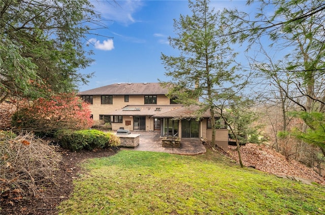 rear view of house with a sunroom, a patio area, and a yard