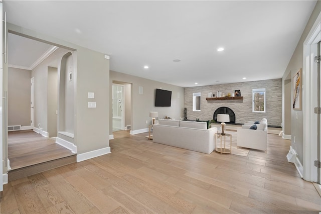 unfurnished living room with light wood-type flooring and crown molding