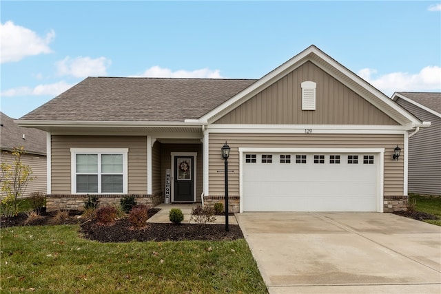 craftsman house featuring a front yard and a garage