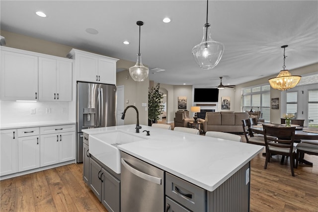 kitchen featuring gray cabinetry, ceiling fan with notable chandelier, white cabinetry, and stainless steel appliances